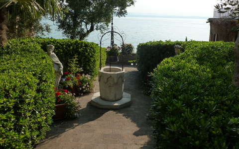 Parkrészlet, háttérben a Garda-tó.  Olaszország