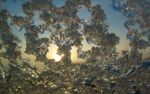 Hajnali napsugár jeges ablak mögül