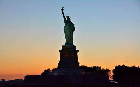a Szabadság szobor a lenyugvó nap előterében, New York, USA