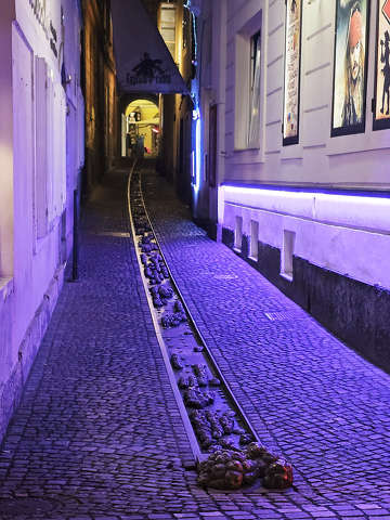 A miniszobor, a „Kutyasétáltató” (Dog Walker) vagy egyszerűen csak a „Kutya” nevet viseli – Ljubljana, Szlovénia.