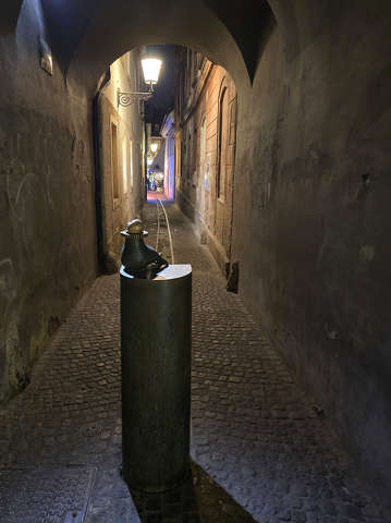 A miniszobor, a „Kutyasétáltató” (Dog Walker) vagy egyszerűen csak a „Kutya” nevet viseli – Ljubljana, Szlovénia.
