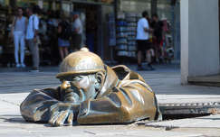 Čumil: bronzszobor egy csatornatisztító emberről, a csatornafedélen pihenve, a járókelőket kukucskálva. - Pozsony, Szlovákia